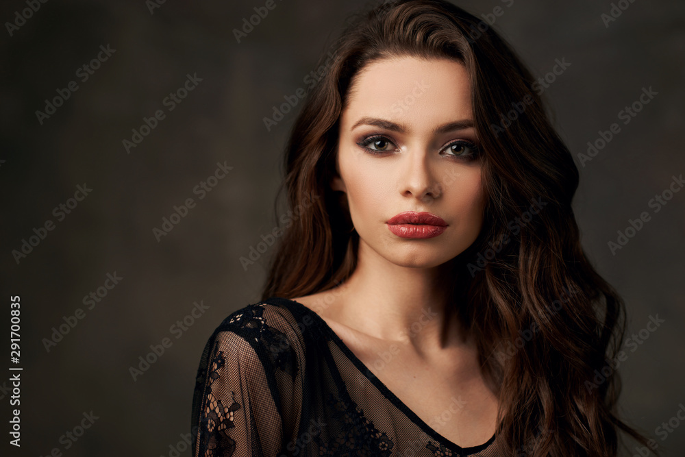 Closeup fashion studio portrait of young beautiful sensual woman with brunette wavy hair and makeup Closeup fashion studio portrait of young beautiful sensual woman with brunette wavy hair and makeup