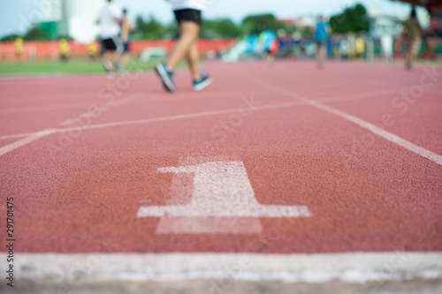 Abstract texture and background of empty running track with number one on the floor and defocused people exercising in background