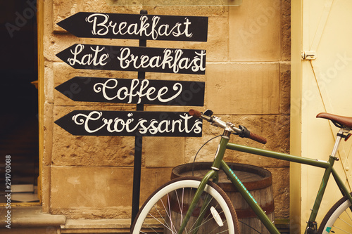 Fototapeta Naklejka Na Ścianę i Meble -  Sign post for cafe in old European city. Outdoor shot