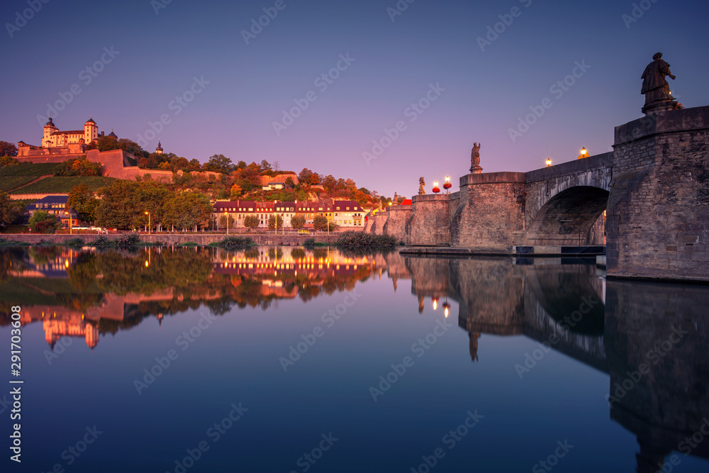 Wurzburg, Germany. Cityscape image of Wurzburg with Old Main Bridge over Main river and Marienberg Fortress during beautiful autumn sunrise.