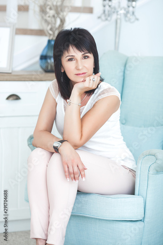 Adult woman interior portrait. Mature female indoors. Cheerful woman closeup portrait. Lady at home.
