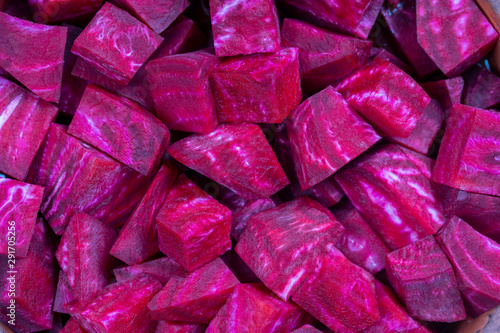 Fresh segments of a red beetroot, closeup. Purple beet slices background, top view