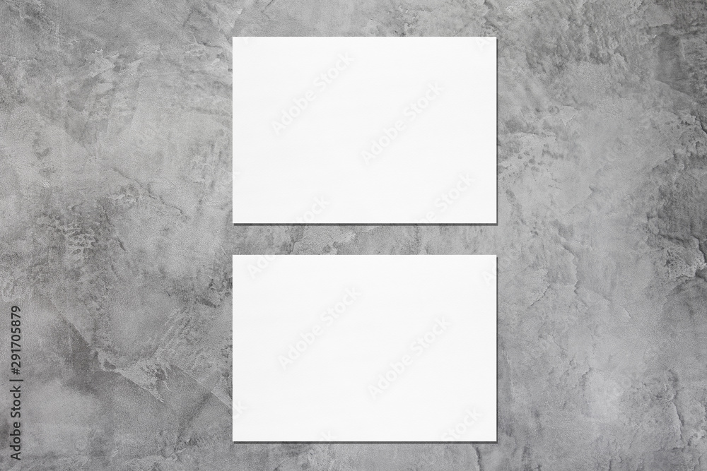Two empty white horizontal rectangle a5 sized card mockups with soft shadows on dark grey concrete wall background. Flat lay, top view Two empty white horizontal rectangle a5 sized card mockups with soft shadows on dark grey concrete wall background. Flat lay, top view