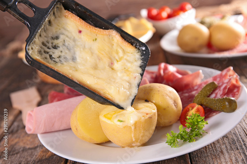 Photography raclette cheese melting with potato, salami and ham