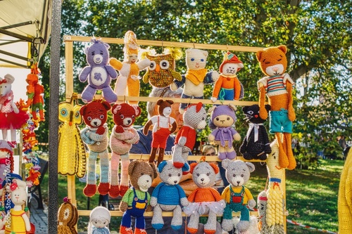 różnokolorowe lalki przytulanki wystawione na jarmarku do sprzedaży