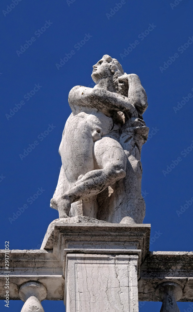 Statue at the top of National Library of St Mark`s Biblioteca Marciana, Venice, Italy