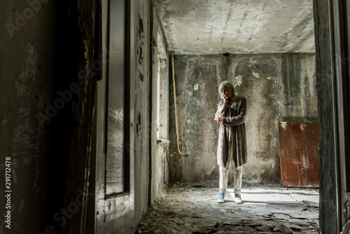 sad senior woman standing in empty and dirty room © LIGHTFIELD STUDIOS