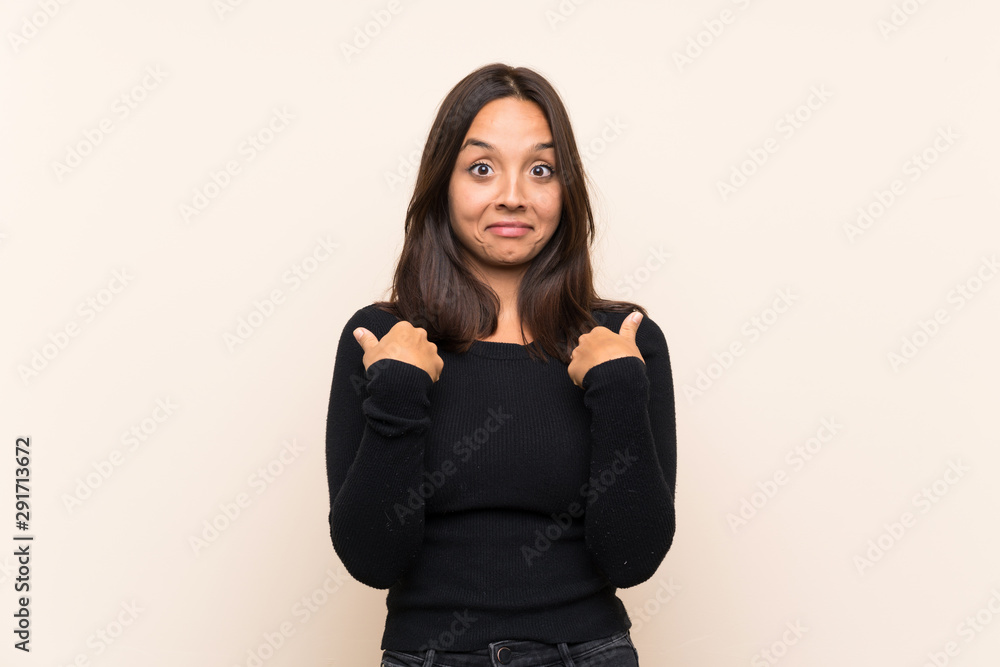 Young brunette woman with white sweater over isolated background with surprise facial expression Young brunette woman with white sweater over isolated background with surprise facial expression