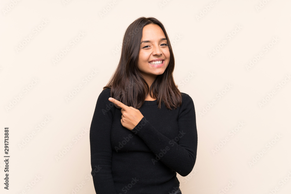 Young brunette woman with white sweater over isolated background pointing to the side to present a product Young brunette woman with white sweater over isolated background pointing to the side to present a product