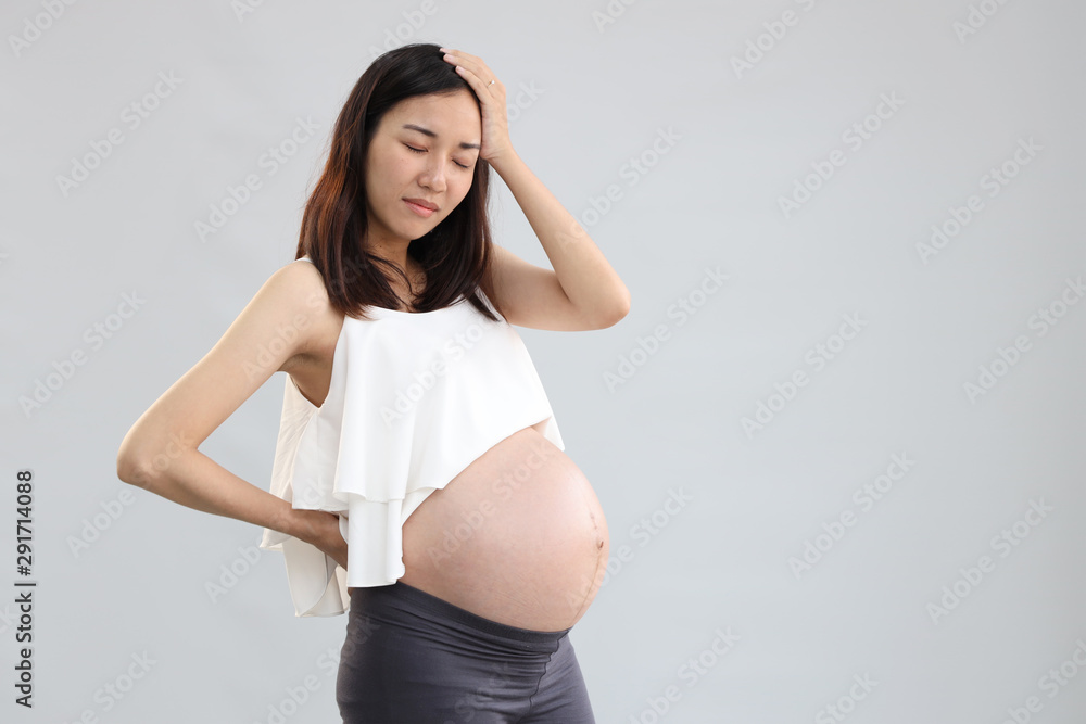 full length young pregnant asian woman is standing and stressed on white background full length young pregnant asian woman is standing and stressed on white background