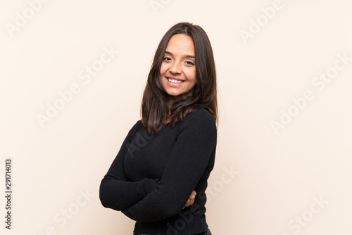 Young brunette woman with white sweater over isolated background with arms crossed and looking forward © luismolinero