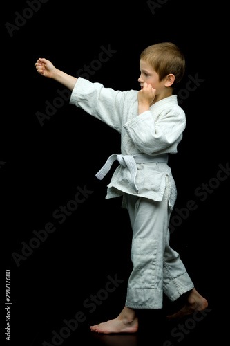 A little boy in a white kimono fulfills blows