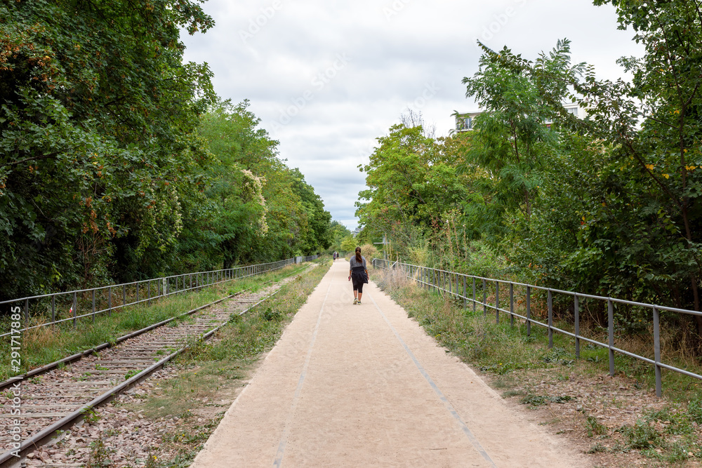 Fototapeta premium Paris, France: People walking on the old railways ring of the Petite Ceinture, transformed as a promenade area.