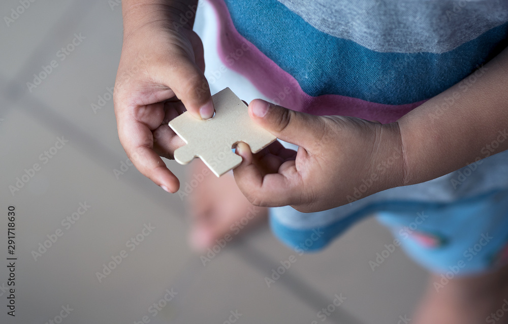 A toddler holding a jigsaw puzzle block
