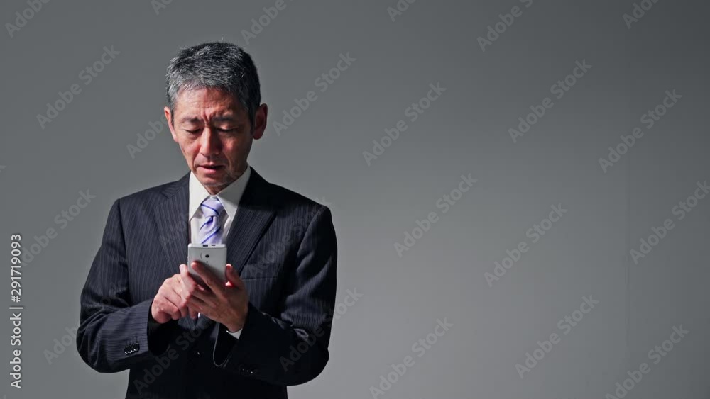 スマホを使う中高年男性 スマホを使う中高年男性