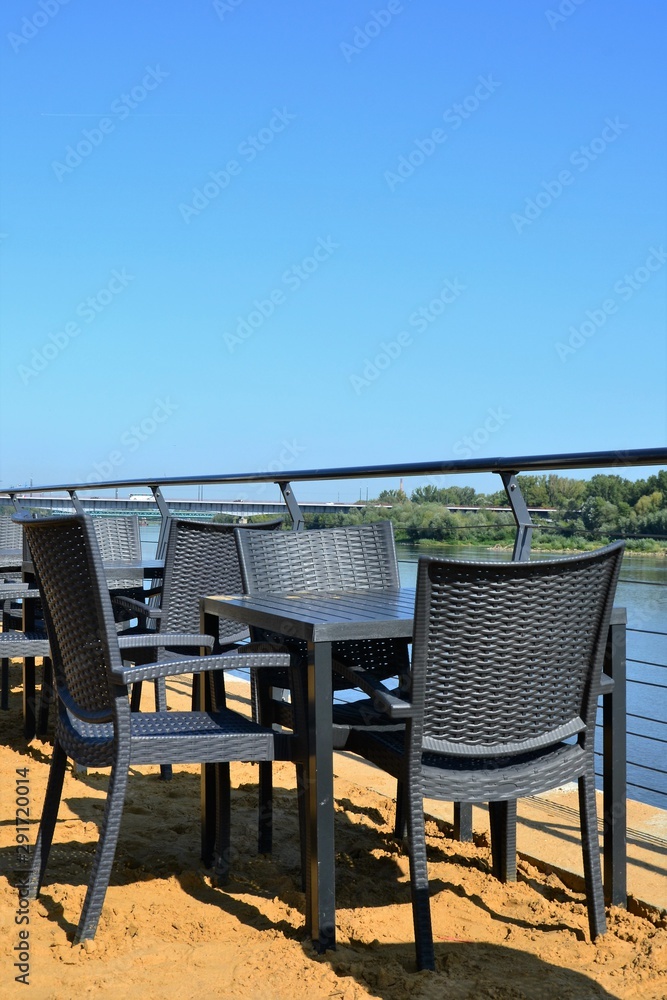 Outdoor tables and chairs, empty beach restaurant table by the river Outdoor tables and chairs, empty beach restaurant table by the river