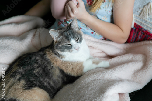 Girl cuddle with her cat while drinking coffee, sitting on couch, cozy