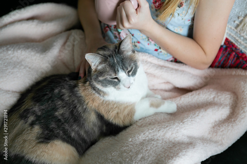 Girl cuddle with her cat while drinking coffee, sitting on couch, cozy