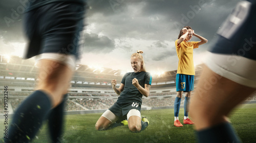 Taste or win. Young female soccer or football player in sportwear celebrating the goal in action at the stadium while gameplay. Concept of healthy lifestyle, professional sport, hobby, motion