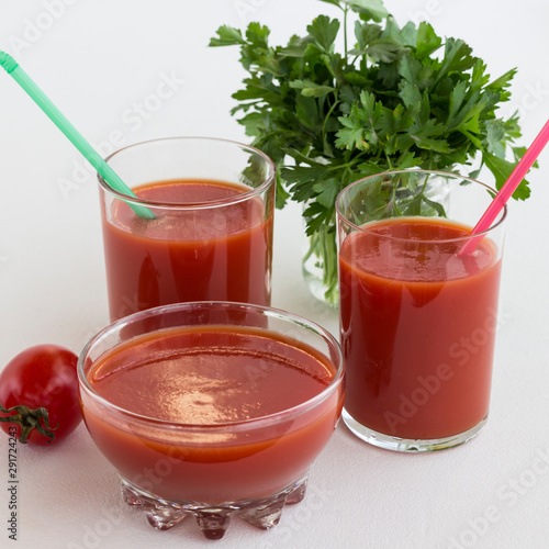 Tomato juice, tomato, bunch of green parsley on a white background