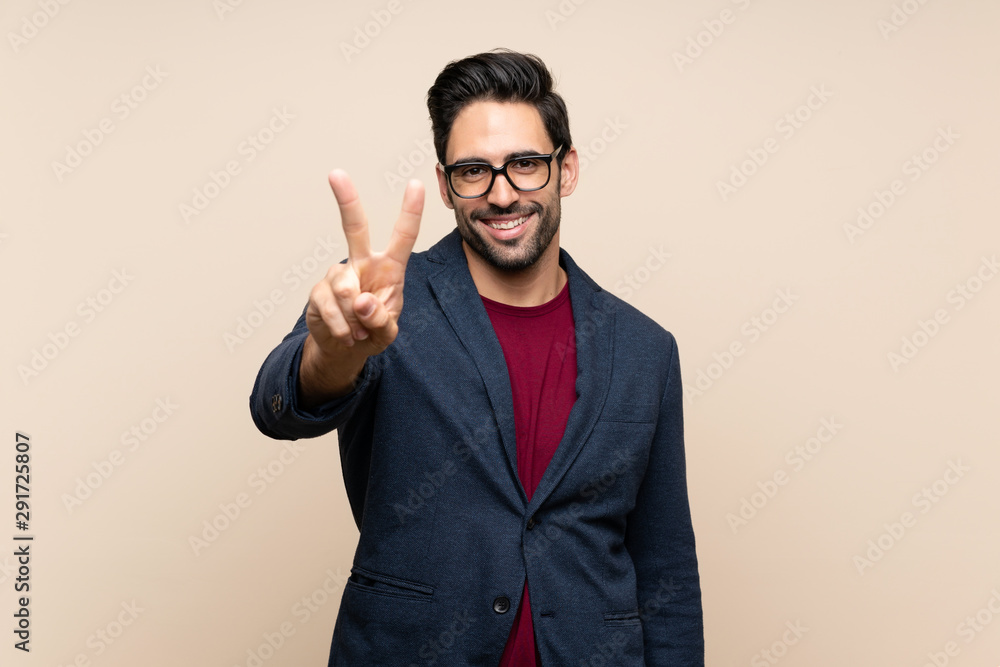 Handsome young man over isolated background smiling and showing victory sign Handsome young man over isolated background smiling and showing victory sign