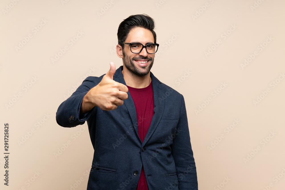 Handsome young man over isolated background with thumbs up because something good has happened Handsome young man over isolated background with thumbs up because something good has happened