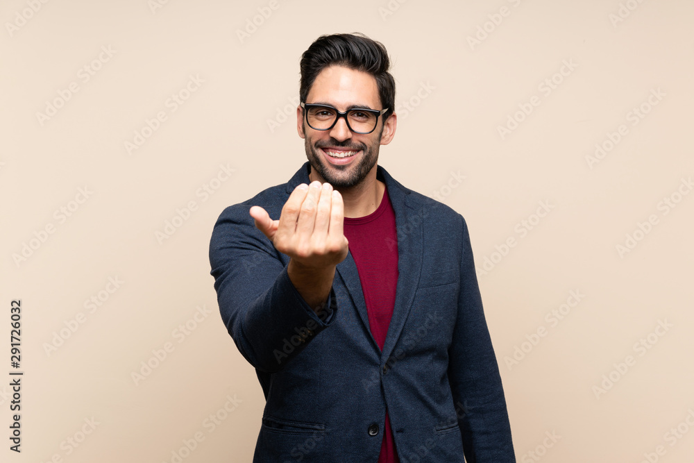 Handsome young man over isolated background inviting to come with hand. Happy that you came Handsome young man over isolated background inviting to come with hand. Happy that you came