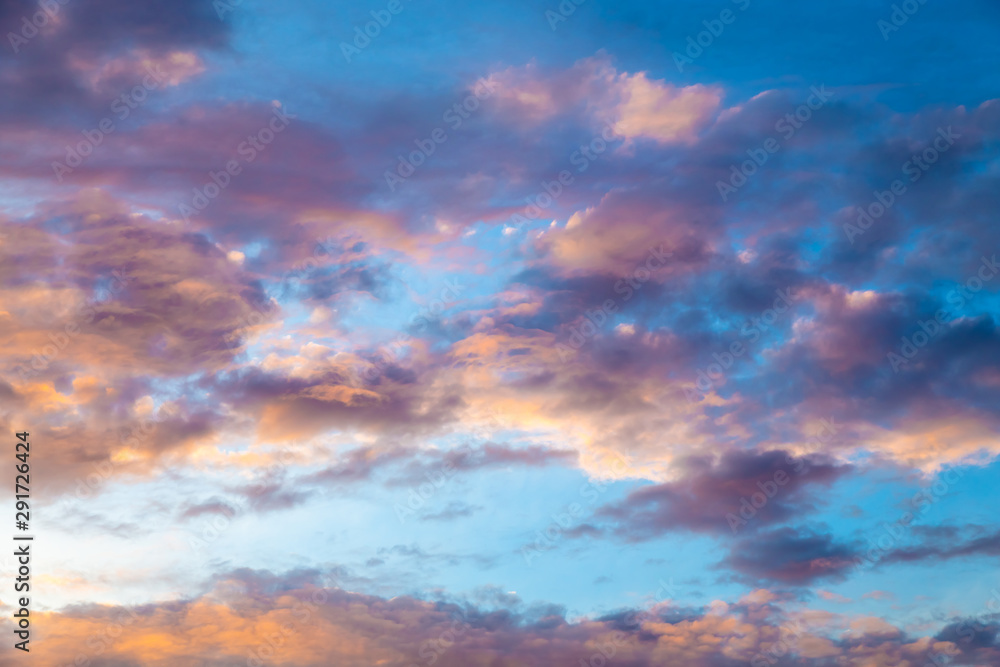 Colorful image of dramatic cloudscape. Amazing clouds of pink, purple, violet, white, gray color on the background of the evening dark sky after sunset.