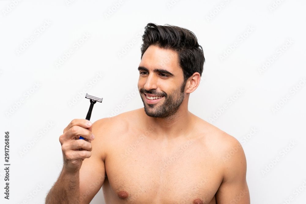 Man shaving his beard over isolated white wall Man shaving his beard over isolated white wall
