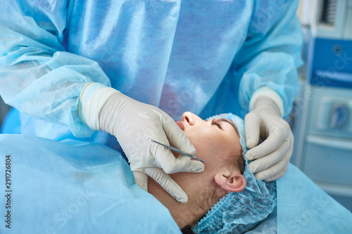 Several doctors surrounding patient on operation table during t