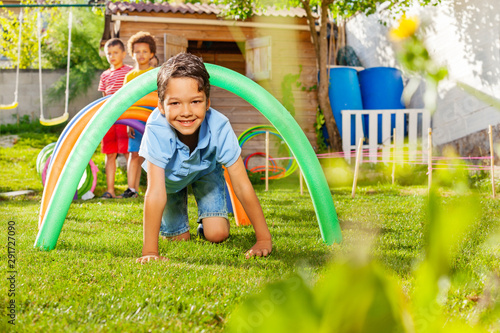 Fotografie Kids crawl under barriers in a competitive game