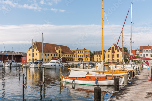 Old sailingboats and huge warehouses in the harbour of Svendborg photo
