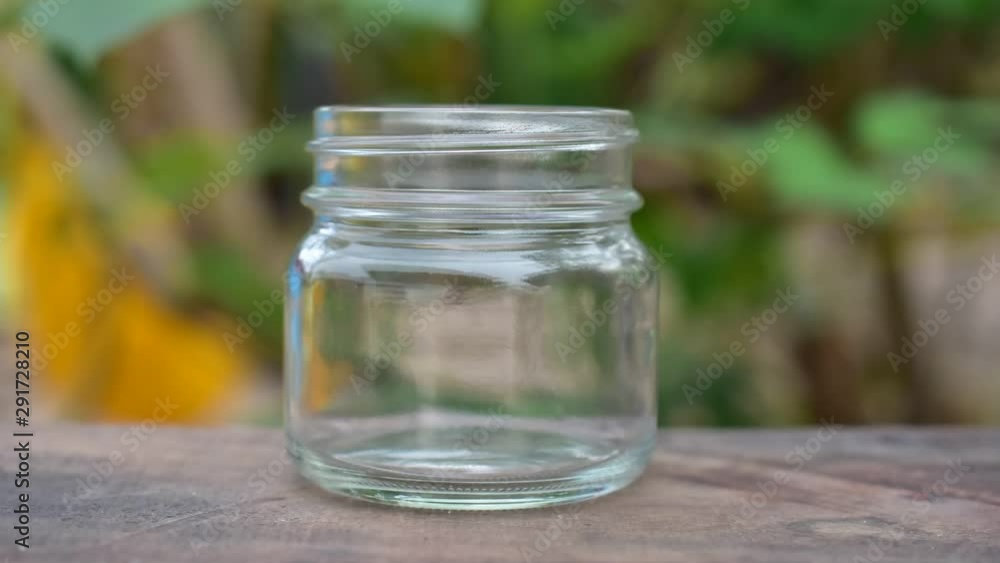 Time lapse Hand saving money coins in glass on table Time lapse Hand saving money coins in glass on table