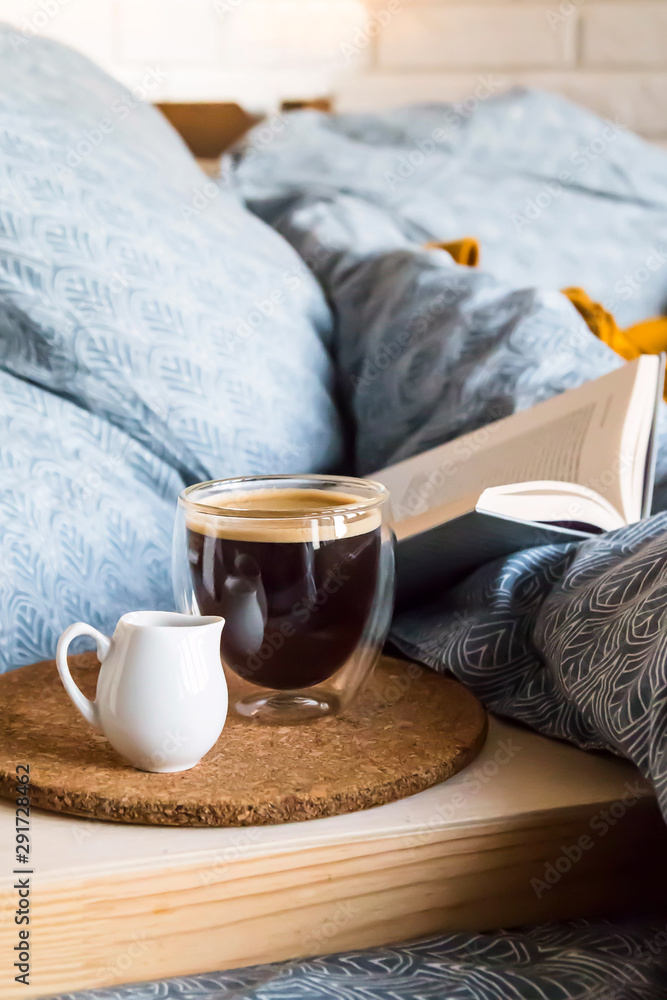 Black coffee in a transparent cup in bed in the autumn morning Black coffee in a transparent cup in bed in the autumn morning