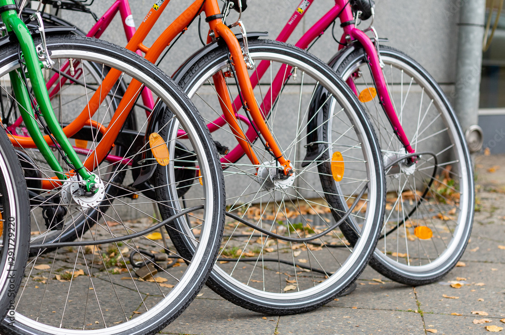 Front wheels of three colorful bicycles