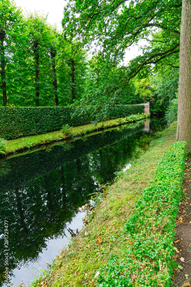 Fototapeta premium Trees with reflection in canal. Public park, Slot Zeist The Netherlands