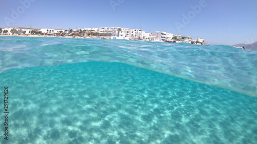 Above and below underwater photo of turquoise clear sea of Ammos sandy beach near port of Koufonisi island, Small Cyclades, Greece