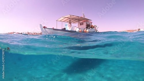 Fototapeta Naklejka Na Ścianę i Meble -  Above and below underwater photo of traditional fishing boat docked in turquoise  clear sea in port of Koufonisi island, Small Cyclades, Greece