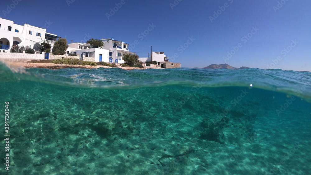 Above and below underwater photo of turquoise clear sea of Ammos sandy beach near port of Koufonisi island, Small Cyclades, Greece