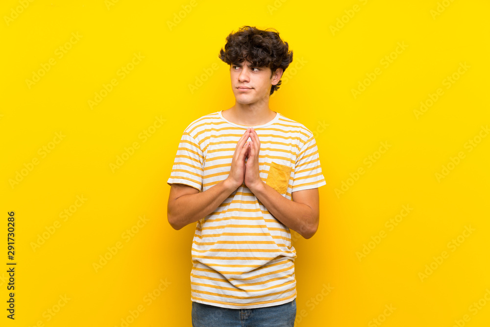 Young man over isolated yellow wall scheming something Young man over isolated yellow wall scheming something
