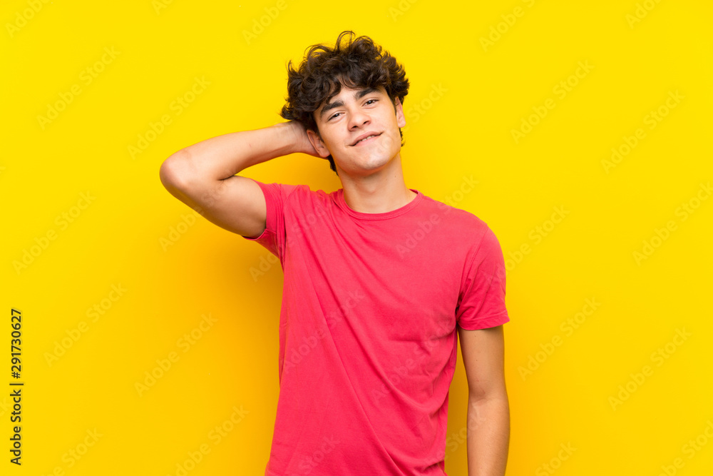 Young man over isolated yellow wall laughing Young man over isolated yellow wall laughing