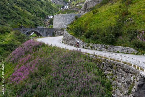 Cyclists along the old road of Mount Gotthard on the Swiss alps