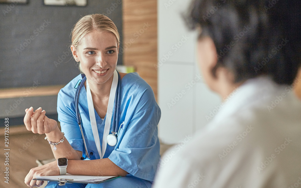 Fototapeta premium Friendly smiling doctor and patient sitting on the couch. Very