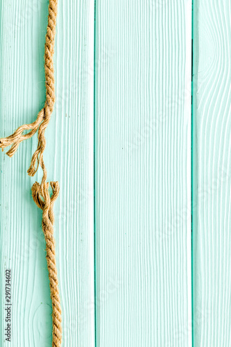 Tearing the rope under stress on mint green wooden background top view copyspace