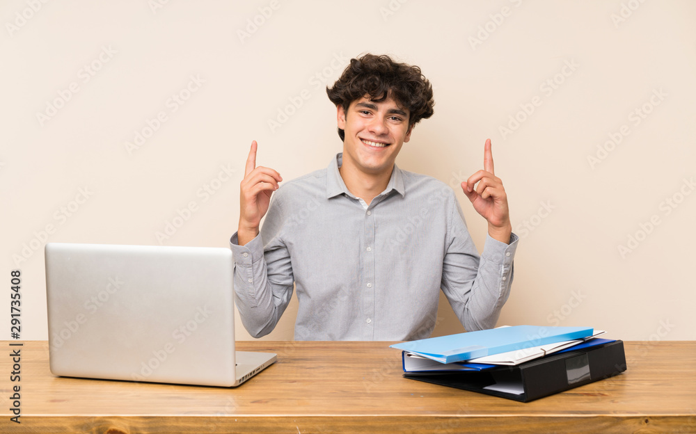Young student man with a laptop pointing up a great idea Young student man with a laptop pointing up a great idea