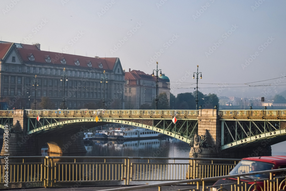 Old bridge with lanterns over river in Prague in the morning