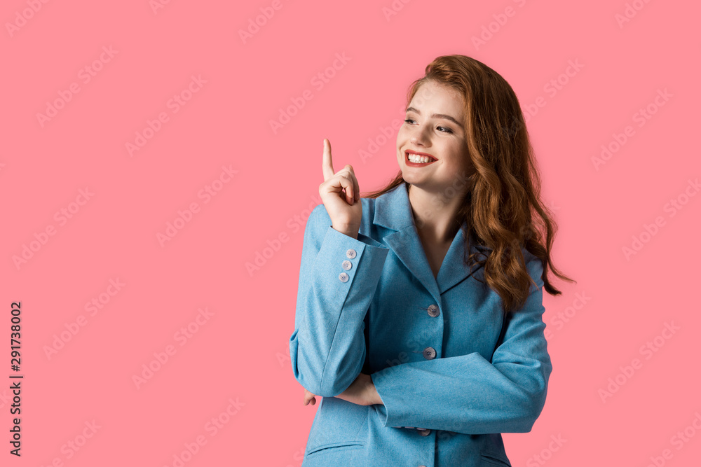 happy redhead girl pointing with finger isolated on pink - obrazy, fototapety, plakaty 