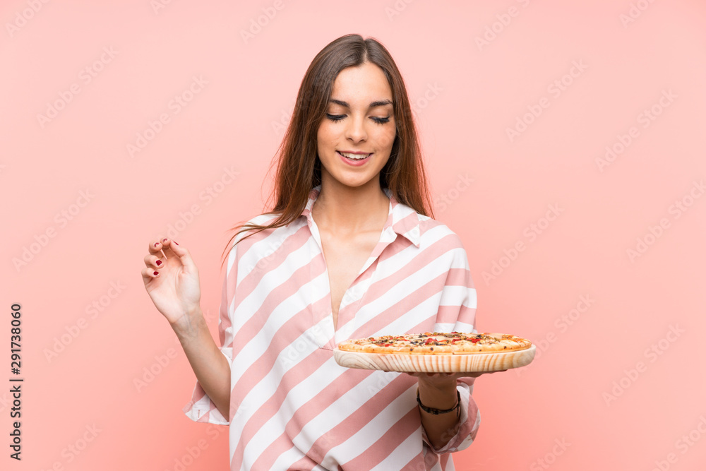 Young woman holding a pizza over isolated pink wall smiling a lot Young woman holding a pizza over isolated pink wall smiling a lot