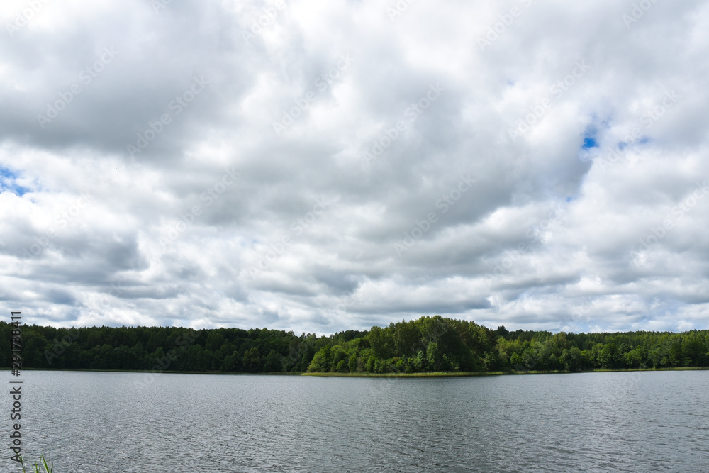Lake, sky, dark strip of forest