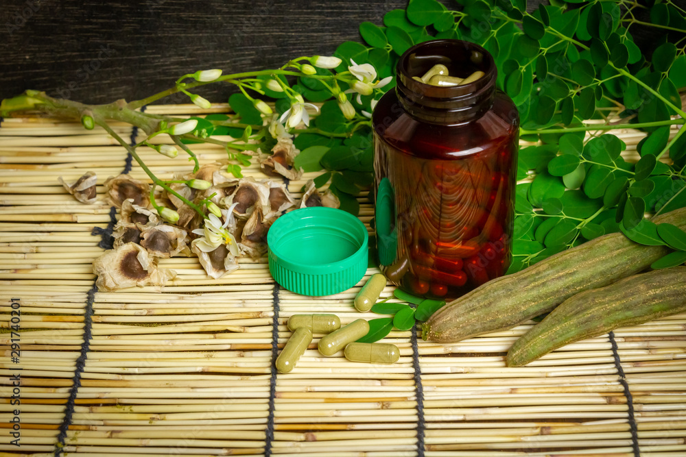 Close-up moringa capsules on wooden background. Moringa products concept. Close-up moringa capsules on wooden background. Moringa products concept.
